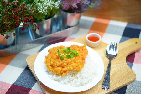 Omelet with chopped shrimp on rice and chili sauce.の写真素材