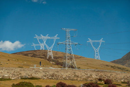 Colorful landscape with beautiful mountain road with high voltage electrical pole structure and blue sky.の写真素材