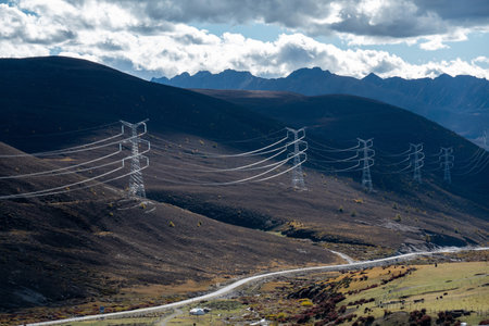 Colorful landscape with beautiful mountain road with high voltage electrical pole structure and blue sky in chinaの写真素材