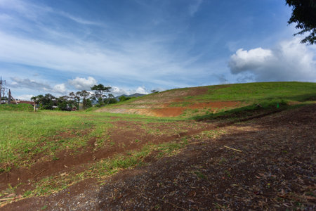 Green meadows with blue sky and clouds background.
Landscape view of green grass on a slope with blue sky and clouds background.の写真素材