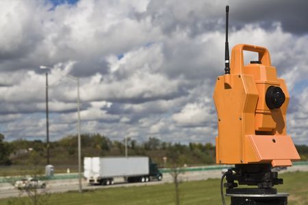 Survey on the highway - orange theodolite.の写真素材