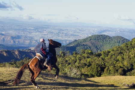 Guatemala City, Guatemala, USA Boy on the horse on the tourist route to Pacaya Volcano. Guatemala City in the background. Seen winter time late afternoonのeditorial素材