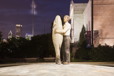 Man With Fish Sculpture by John G Shedd Aquarium in downtown of Chicago. Seen summer evening. AON Center in the background. Chicago, Illinois, USA, September 1, 2011のeditorial素材