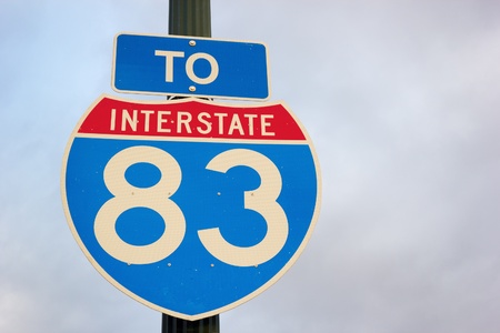 To highway 83 - road sign against the cloudy sky.の写真素材