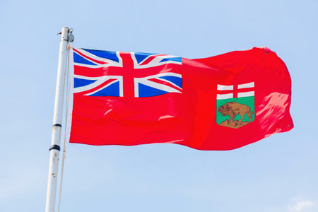 Manitoba flag against blue sky. Winnipeg, Manitoba, Canada.