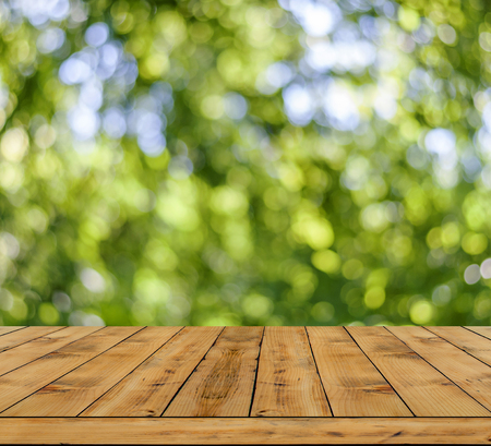 Green bokeh abstract light background a lot forest bokeh with wooden tableの写真素材