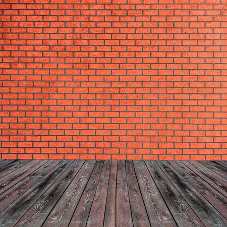 Textured red brick wall with brown wooden floor insideの写真素材