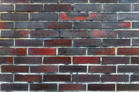 Background of old black and red brick wallの写真素材