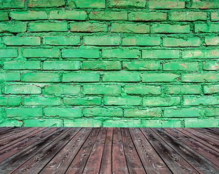 Textured green brick wall with brown wooden floor insideの写真素材