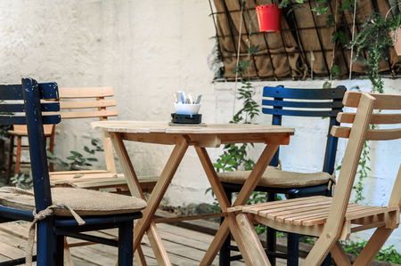 Wooden table and black chairs in the cafe gardenの写真素材