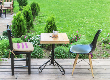 Wooden table and black chairs in the cafe gardenの写真素材