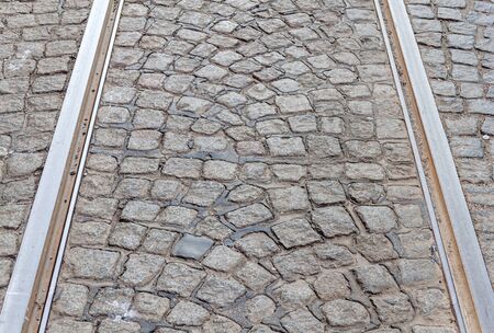 Old rail lines on cobbled road surfaceの写真素材