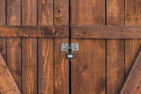 Padlocked on brown wooden doorの写真素材