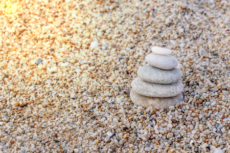 Stack of zen stones on beach with burning sunの写真素材