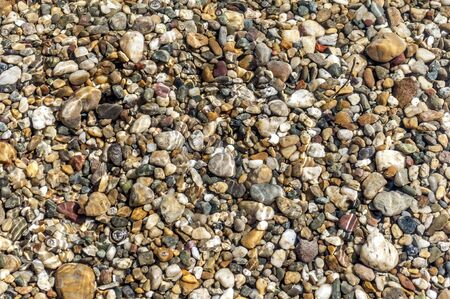 Stones on beach and sea water in sunset lightの写真素材