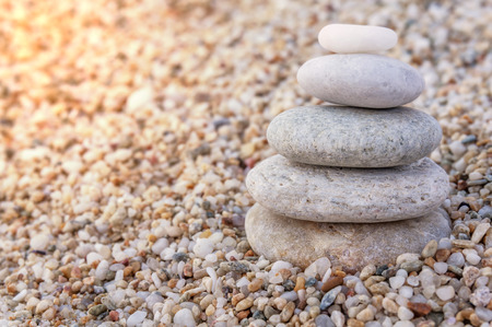 Stack of zen stones on beach with burning sunの写真素材