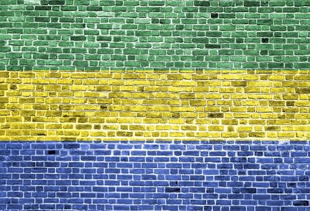 Flag of Gabon painted on brick wall, background textureの写真素材