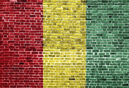Flag of Guinea painted on brick wall, background textureの写真素材