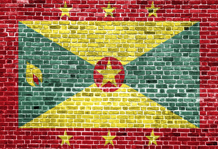 Flag of Grenada painted on brick wall, background textureの写真素材