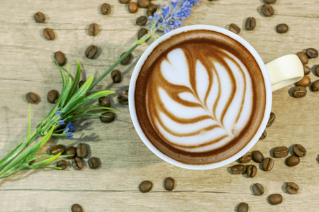 Cup of espresso hot drink with coffee beam and lavender flower on wooden tableの写真素材