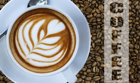 Cup of hot espresso drink on left with coffee bean background and written word COFFEEの写真素材