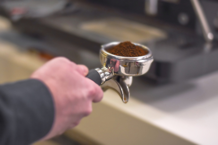 Full and ready for tamping espresso spoon in barista handの写真素材