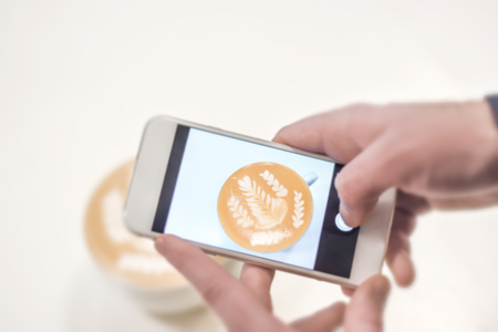 Mobile fotograph shoot of cafe latte on white tableの写真素材