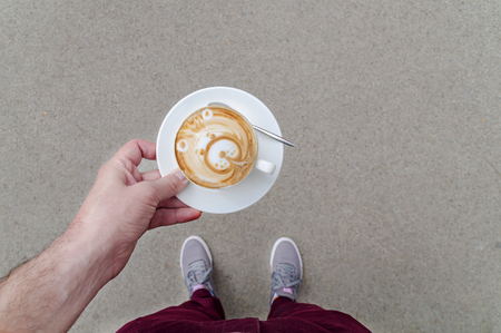 Top view of man holding coffee with milkの写真素材