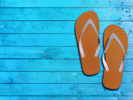 Two orange man lifestyle relax flip flops on blue wooden floorの写真素材
