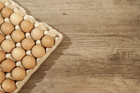 Close up eggs in carton package on a wooden table for bakingの写真素材