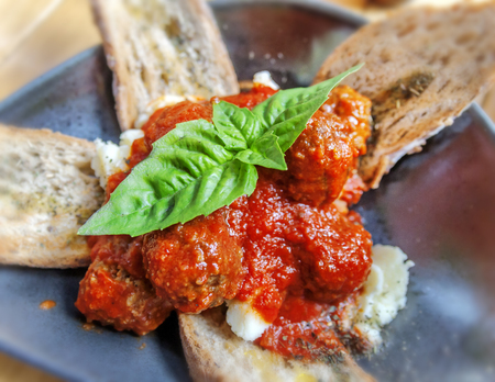 Meatballs in a plate with bread on tableの写真素材