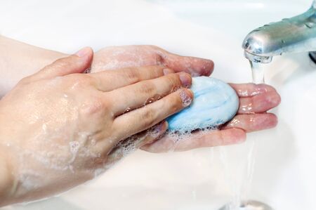 Washing of hands with soap under running waterの写真素材