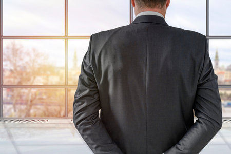 Businessman back over in elegant custom tailored expensive suit posing in the office