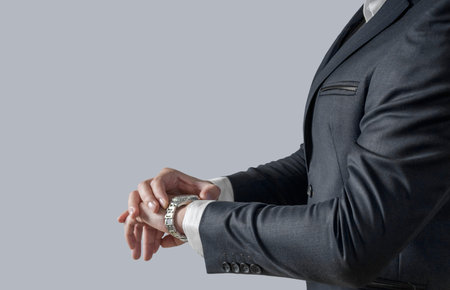 Businessman looking at his watch and watching the time