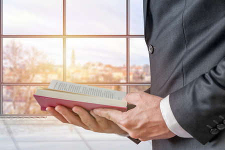 Office businessman in a suit holding a open bookの写真素材