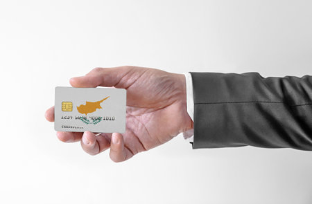 Bank credit plastic card with flag of Cyprus holding man in elegant suitの写真素材