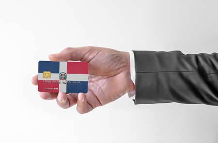 Bank credit plastic card with flag of Dominican Republic holding man in elegant suitの写真素材