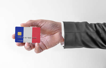 Bank credit plastic card with flag of France holding man in elegant suitの写真素材
