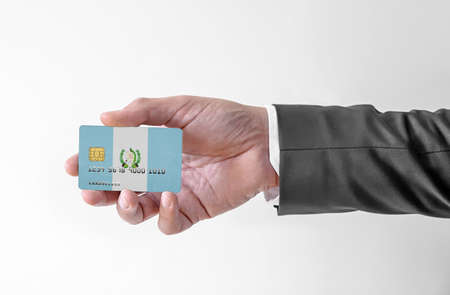 Bank credit plastic card with flag of Guatemala holding man in elegant suitの写真素材