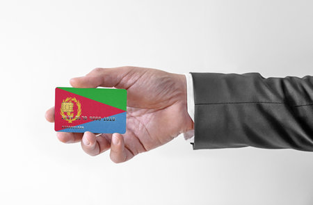 Bank credit plastic card with flag of Eritrea holding man in elegant suitの写真素材