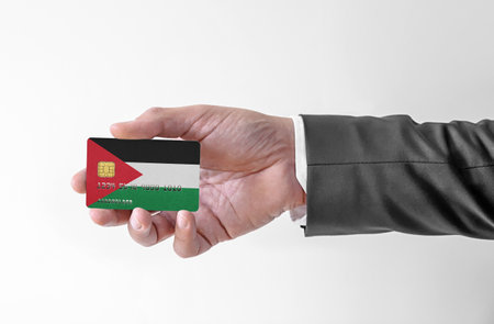 Bank credit plastic card with flag of Jordan holding man in elegant suitの写真素材