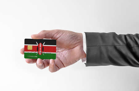 Bank credit plastic card with flag of Kenya holding man in elegant suitの写真素材