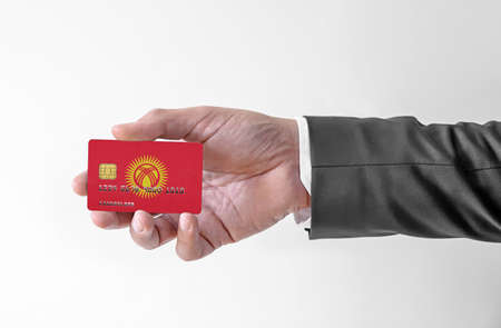 Bank credit plastic card with flag of Kyrgyzstan holding man in elegant suitの写真素材