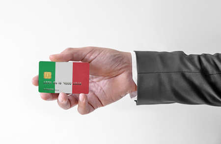 Bank credit plastic card with flag of Italy holding man in elegant suitの写真素材