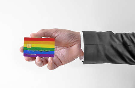 Bank credit plastic card with flag of LGBT holding man in elegant suitの写真素材
