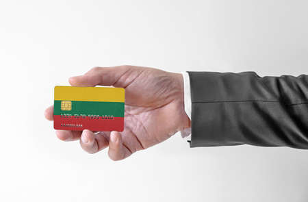 Bank credit plastic card with flag of Lithuania holding man in elegant suitの写真素材