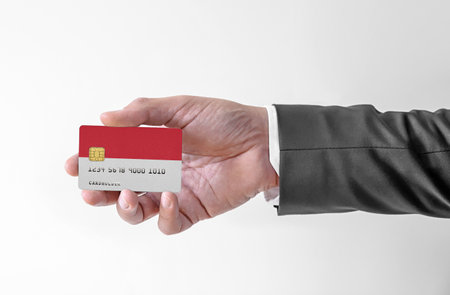 Bank credit plastic card with flag of Indonesia holding man in elegant suitの写真素材