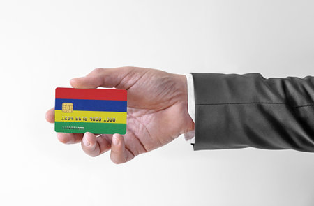 Bank credit plastic card with flag of Mauritius holding man in elegant suitの写真素材
