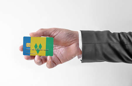 Bank credit plastic card with flag of Saint Vincent and the Grenadines holding man in elegant suitの写真素材