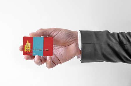 Bank credit plastic card with flag of Mongolia holding man in elegant suitの写真素材